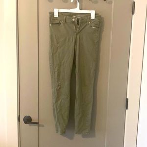 Green skinny jeans with distress